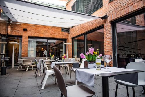 a restaurant patio with tables and chairs and flowers at Hotel Nicolaus in Toruń