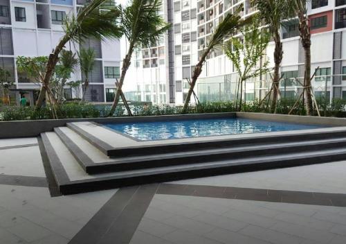 una piscina frente a un edificio alto en [SLEEPS 4 PAX] @ I-CITY en Shah Alam