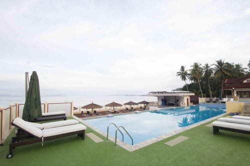 einen Pool mit zwei Liegestühlen und das Meer in der Unterkunft Foxy's Beach Resort in San Vicente