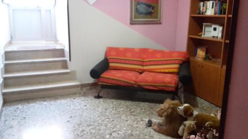 a living room with a red couch and a stair case at Affittacamere di Fabio Principale in Talsano