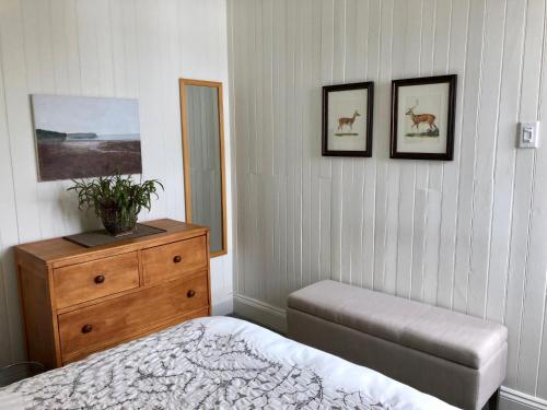 a bedroom with a bed and a dresser and pictures on the wall at Maison du Photographe in Bic