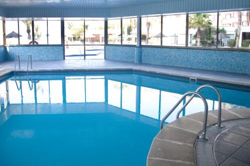 a swimming pool with blue water in a building at TRH Jardín Del Mar in Santa Ponsa