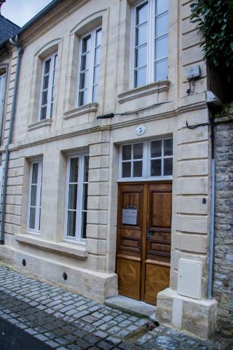 a stone building with a large wooden door at Villa Des Ursulines in Bayeux