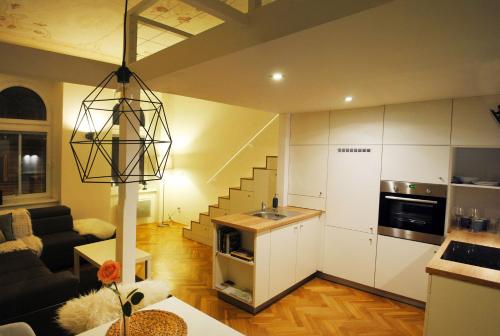 Apartments Centre in Style في أولوموك: غرفة معيشة مع مطبخ ودرج
