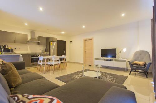 a living room with a couch and a table and a kitchen at Accra Luxury Apartments at The Gallery in Accra