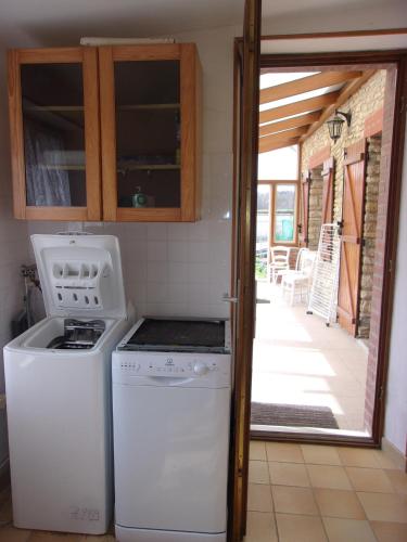 a kitchen with a stove and a washer at Gîte à la campagne in Cressonsacq