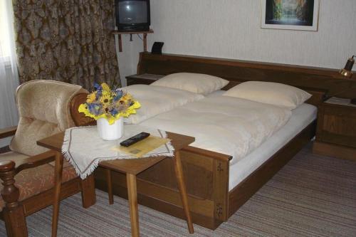 ein Schlafzimmer mit einem Bett, einem Tisch und einer Couch in der Unterkunft Landhaus Christophorus in Mallnitz