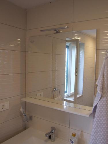 a bathroom with a large mirror and a sink at Holiday Home Katia in Pučišća