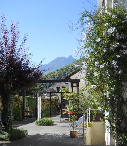 a garden with a gate and a mountain in the background at Les Rochers in Saint-Savin