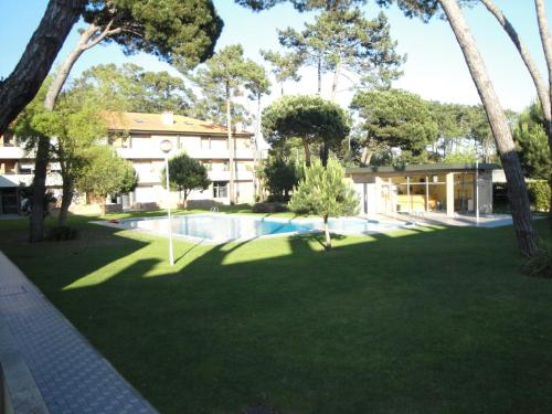 a large yard with a building and a swimming pool at Lirios Nature, Beach & Pool in Fão