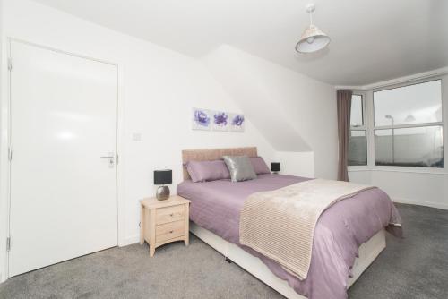ein Schlafzimmer mit einem lila Bett und einem Fenster in der Unterkunft Hylton Road in Sunderland