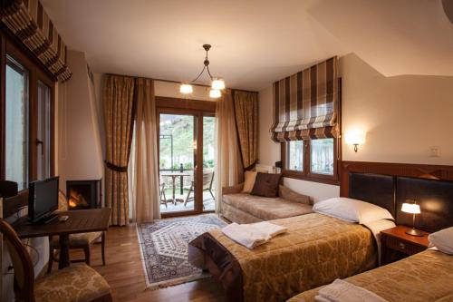 a hotel room with two beds and a couch at Guesthouse Thea in Naousa