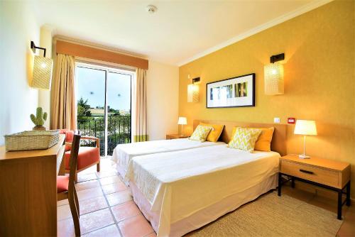 クアルテイラにあるT3 Vila Sol Villageの大きな白いベッドと窓のある寝室