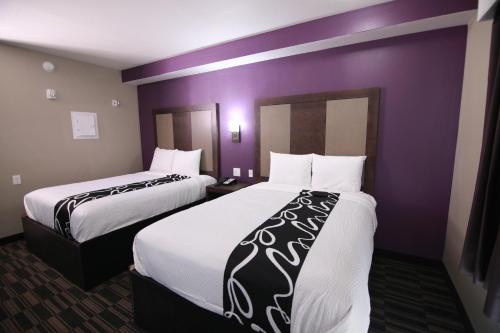 two beds in a hotel room with purple walls at Home Inn and Suites Memphis in Memphis