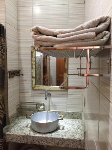 uma casa de banho com lavatório, espelho e toalhas em Fazenda San Francisco em Pôrto