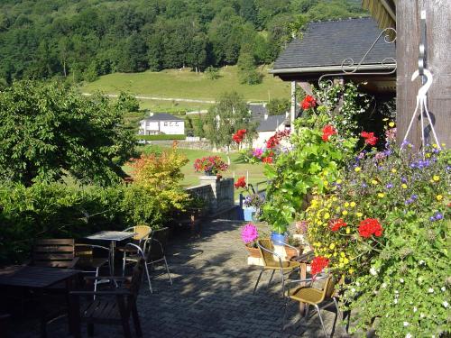 a garden with tables and chairs and colorful flowers at Les Rochers in Saint-Savin