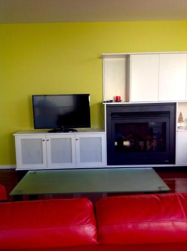 a living room with a couch and a flat screen tv at Waterloo Cottage in Hobart