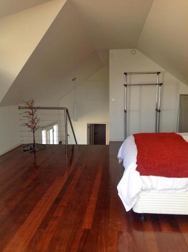 a bedroom with a bed with a red blanket at Waterloo Cottage in Hobart