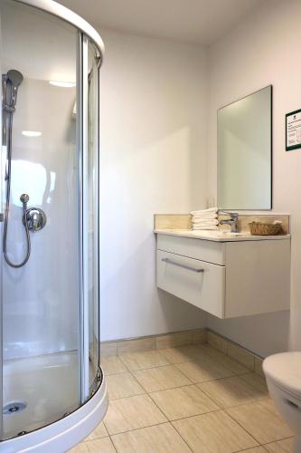 a bathroom with a shower and a sink at The Victoria Hotel Dunedin in Dunedin