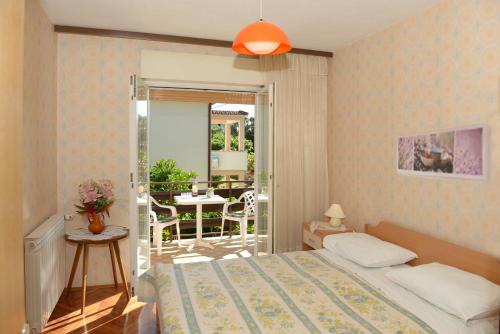 1 Schlafzimmer mit einem Bett und einem Balkon mit einem Tisch in der Unterkunft Apartmani Ivo in Petrcane