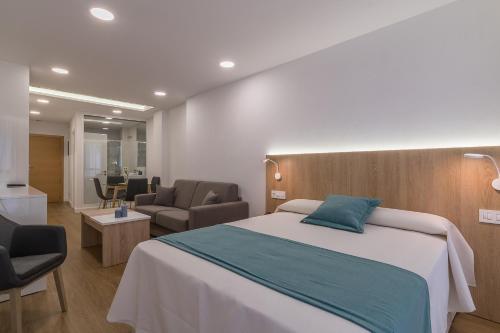 1 dormitorio con 1 cama y 2 sillas en Lofts MSH Canarias en Las Palmas de Gran Canaria