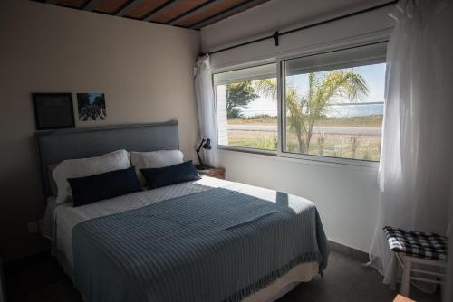 a bedroom with a bed and a large window at Aparthotel la Música y el Mar in Maldonado