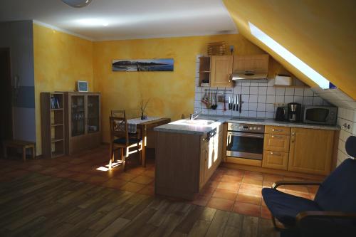 a kitchen with wooden cabinets and a counter top at Ferienwohnung Koserow in Koserow