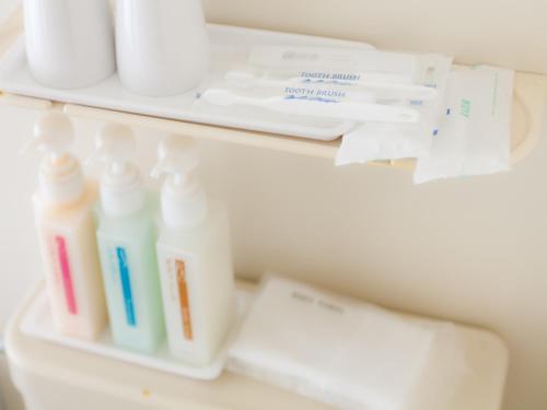 a shelf with bottles of detergent and toiletries at Koga Central Hotel in Koga