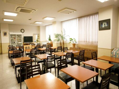 a classroom with tables and chairs and a chalkboard at Koga Central Hotel in Koga