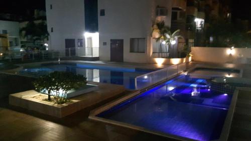 a large swimming pool with blue lights in a house at Apto Ingleses à 50mts da praia in Florianópolis