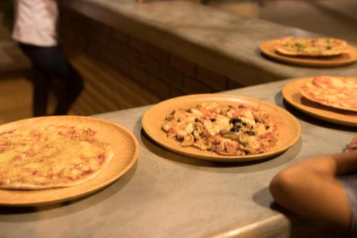 four pizzas sitting on top of a counter at Baja Canoas Hotel in Canoas De Punta Sal
