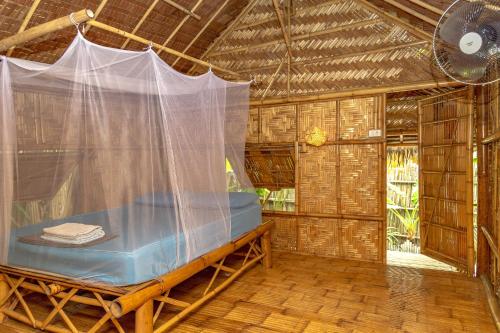 Cette chambre comprend un lit dans une cabane de paille. dans l'établissement Forra Dive Resort Sunrise, à Koh Lipe