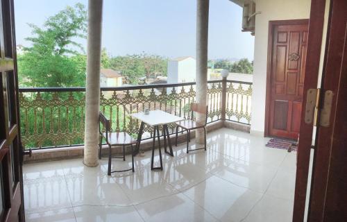 porche con mesa y sillas en el balcón en Nam Phương Riverside Villa en Hue