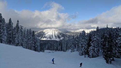 two people skiing down a snow covered mountain at White Pass Log Cabin Luxury Retreat in Rimrock