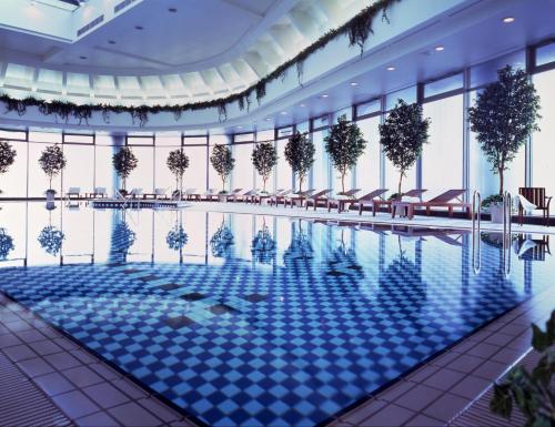 a large swimming pool in a building with windows at Imperial Hotel Osaka in Osaka