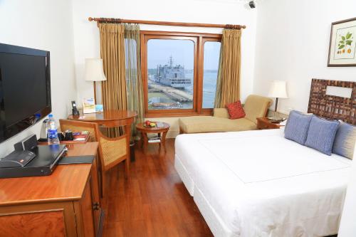 a hotel room with a bed, desk and television at Taj Malabar Resort & Spa, Cochin. in Cochin