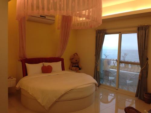 a bedroom with a bed with a teddy bear on it at Taroko Bay B&B in Xincheng