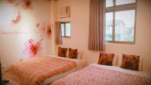 a bedroom with two beds and a window at Guiju Lin Garden Homestay in Nanzhuang