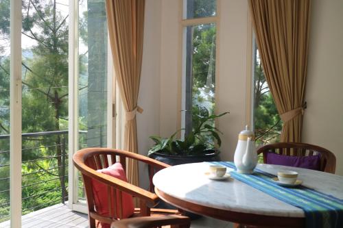 comedor con mesa y sillas y ventana grande en Villa Babeh, en Bandung