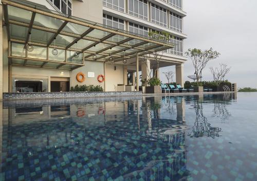 a swimming pool in front of a building at Grand Mercure Solo Baru in Solo