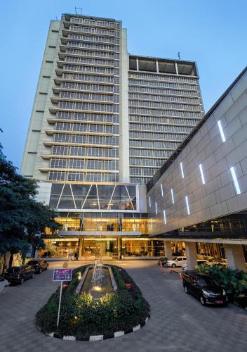 a large building with a parking lot in front of it at Grand Mercure Solo Baru in Solo