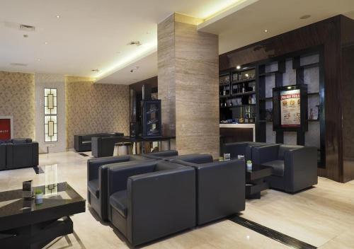 a restaurant with couches and a bar at Grand Mercure Solo Baru in Solo