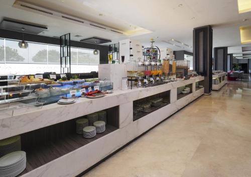 a large kitchen with a buffet in a restaurant at Grand Mercure Solo Baru in Solo