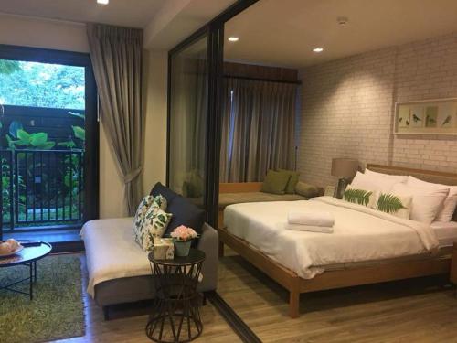 - une chambre avec un grand lit et un canapé dans l'établissement Rain Condo Ground Floor Cha-am Hua Hin, à Cha Am