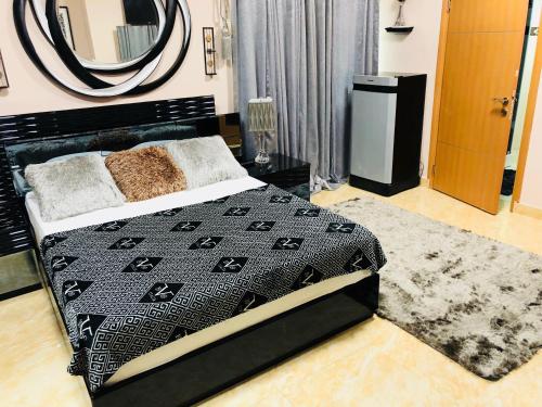 a bedroom with a black bed and a mirror at Westland Villa in Accra