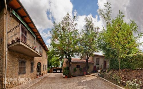 eine leere Einfahrt vor einem Gebäude mit Bäumen in der Unterkunft Agriturismo Villino del Grillo in San Gimignano