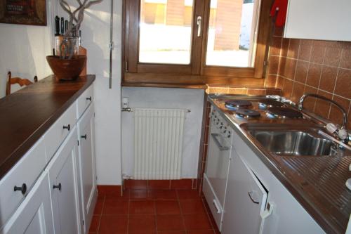 eine kleine Küche mit einem Waschbecken und einem Fenster in der Unterkunft Lara 1 in Verbier