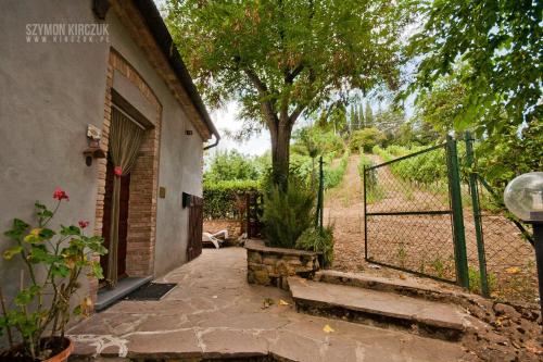 an entrance to a house with a gate and a tree at Agriturismo Villino del Grillo in San Gimignano