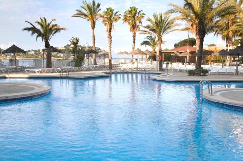 a pool at a resort with palm trees at TRH Jardín Del Mar in Santa Ponsa
