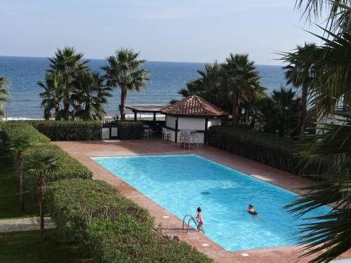 2 personnes dans une piscine avec l'océan en arrière-plan dans l'établissement Vue sur mer et montagnes, à Moriani-Plage